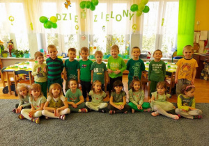 Zdjęcie grupowe – dzieci ubrane są w stroje w kolorze zielonym.